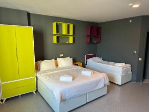 two beds in a room with yellow and green walls at Aderans Hotel in Istanbul