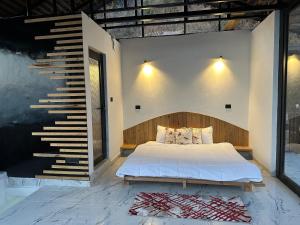 a bedroom with a bed and a staircase at Snow Biscuit Huts in Dharamshala