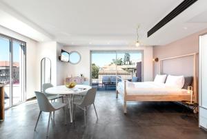 um quarto com uma cama, uma mesa e cadeiras em Jaffa Port TLV Hotel Apartments יפו תל אביב em Tel Aviv