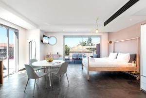 1 dormitorio con 1 cama, mesa y sillas en Jaffa Port TLV Hotel Apartments יפו תל אביב, en Tel Aviv