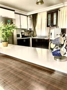 a kitchen with a large white counter with chairs at Airport forest villa hotel in Arnavutköy