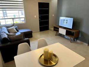 a living room with a table and a tv at Workation Montpellier in Santa María Coronanco