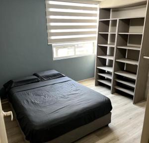 a bedroom with a bed and a window and shelves at Workation Montpellier in Santa María Coronanco