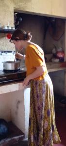 a woman standing in a kitchen preparing food at Thomasha Homestay & Tuk Tuk Tour in Wellawaya
