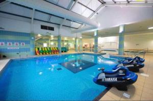 een groot zwembad met twee boten in een fitnessruimte bij Inviting 6 Birth Lodge - Southview Skegness in Skegness