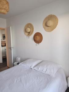 sypialnia z trzema kapeluszami wiszącymi na ścianie w obiekcie Eau Bleue d'Eden w mieście Saint-Hilaire-de-Riez