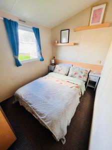 a small bedroom with a bed and a window at Lola’s Caravan. Your home away from home. in Parkeston