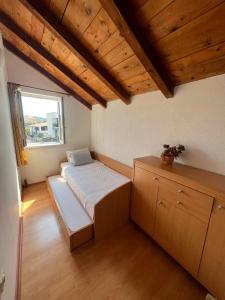 a small bedroom with a bed and a window at Villa Sunce in Jezera