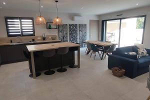 eine Küche und ein Wohnzimmer mit einem Tisch und einer Couch in der Unterkunft L'Orée des Alpilles Proche Centre ville St Rémy de Provence in Saint-Rémy-de-Provence