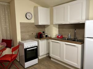 a kitchen with white cabinets and a clock on the wall at MareLuna Guest House in Naples