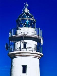 un faro blanco con una cúpula azul en la parte superior en La Calita del Versalles, en Cullera