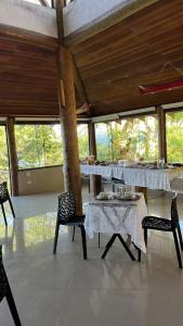 a dining room with tables and chairs and windows at CASA DE TUCA in Ilhabela