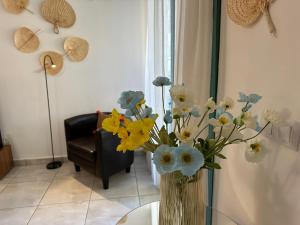 un jarrón lleno de flores sentado en una mesa en Las Olas DM cozy 2-bedrooms apartment en Maspalomas