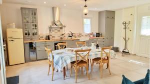 uma cozinha com mesa e cadeiras num quarto em Gite du Four à Pain 4* - Le Domaine des Cyclamens em Verneuil-sur-Indre