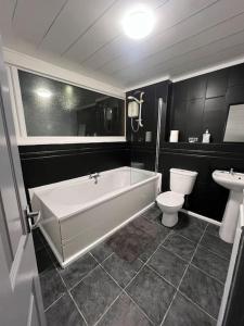 a bathroom with a tub and a toilet and a sink at Washington Residence in Usworth