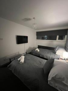 a bedroom with two beds and a flat screen tv at Washington Residence in Usworth