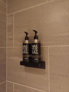 two bottles of next to each other on a tile wall at The Royal Hotel Cardiff in Cardiff