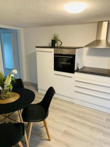 a kitchen with white cabinets and a table with chairs at Blaue 8 -2 in Leezen