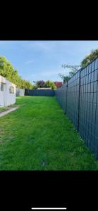 einen Zaun vor einem Hof mit grünem Gras in der Unterkunft Blaue 8 -2 in Leezen