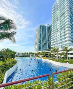 a swimming pool in a resort with tall buildings at Condo At Azure North San Fernado in San Fernando