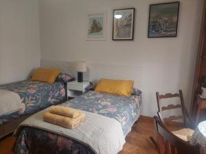 una habitación con dos camas y una mesa y una silla en La Tioca, en Cuenca
