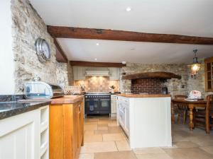 una cocina con paredes de piedra y una isla en una habitación en 3 Bed in Corfe Castle DC084, en Corfe Castle