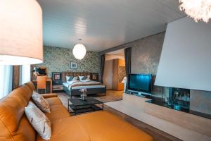 ein Wohnzimmer mit einem Sofa, einem Bett und einem TV in der Unterkunft Hotel Palatino in Sundern