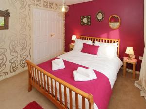 a bedroom with a large bed with purple walls at 4 Bed in Druridge Bay CN102 in Hadston
