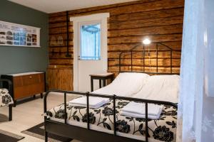 1 dormitorio con 1 cama con pared de madera en Urvaste Vana-Söödi Puhkemaja, en Urvaste