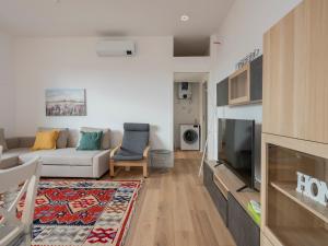 a living room with a white couch and a tv at [IHost Flat] - Giambellino 131-2 in Milan