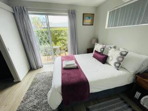 a bedroom with a bed and a window with a table at D'urban Ridge Self catering Apartment in Cape Town +11 photos