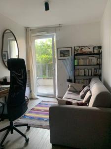 uma sala de estar com um sofá, uma cadeira e uma janela em Lovely room in Nanterre Université em Nanterre