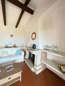 Una sala de estar con un sofá y una chimenea. en EdelBlu - Breathtaking seaview penthouse, en Castelsardo