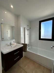 ein Badezimmer mit einem Waschbecken, einer Badewanne, einem Waschbecken und einem Spiegel in der Unterkunft Casa Cristina, Corvera in Corvera + 16 Fotos