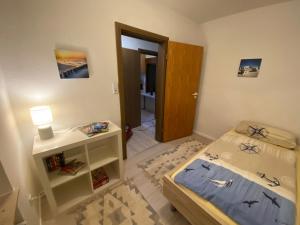 a small bedroom with a bed and a night stand at Am Deich in Norddeich