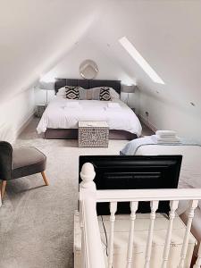 a white bedroom with a bed and a chair at The Mews Cottage, with parking, Yarm in Yarm