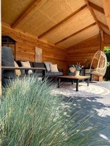 a patio with couches and a table and a bench at ZeeLand & Meer in Kamperland