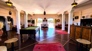 a living room with a pool table in the middle at Kasbah Caracalla in Aït Zat