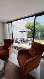 sala de estar con 2 sillas y patio en Maison avec jardin à 2 minutes à pied de la plage en Temara