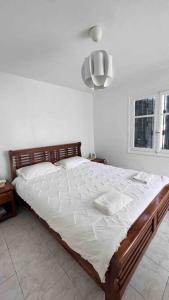 1 dormitorio con 1 cama grande con sábanas blancas en Maison avec jardin à 2 minutes à pied de la plage en Temara