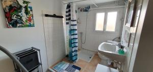 a bathroom with a sink and a toilet and a window at Maison bleu océan in Saint-Palais-sur-Mer +19 photos