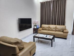 Sala de estar con 2 sofás y mesa de centro en Restu Villa Homestay en Tuaran