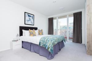 sypialnia z dużym łóżkiem i dużym oknem w obiekcie Large Canary Wharf 2 Bed Apartment with High Rise view w Londynie