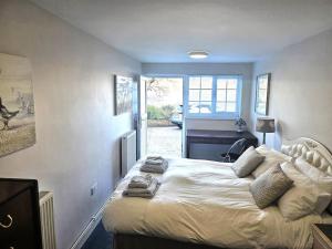 a bedroom with a bed with towels on it at Beach Cottage, with stunning views in Cosheston