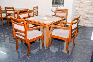 a wooden table with four chairs and a table and a table and chairsktop at WISMA MIRAH 1 in Kamparganya