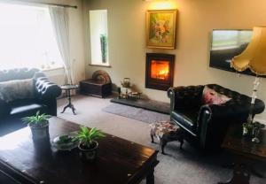 a living room with a couch and a fireplace at Beach Cottage, with stunning views in Cosheston