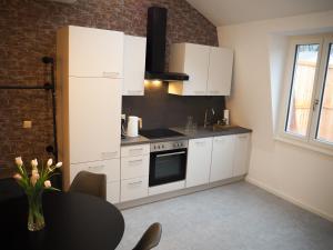 a kitchen with white cabinets and a table and a window at Loft Schottenau in Neusiedl am See