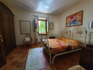 a bedroom with a bed and a chair and a window at Agrifoglio B&B con giardino in Aritzo