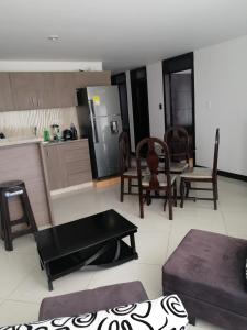 una cucina e un soggiorno con tavolo e sedie di Moderno apartamento para huespedes a Ipiales