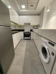 a large kitchen with a washer and dryer in it at Oval Tower Business Bay in Dubai
